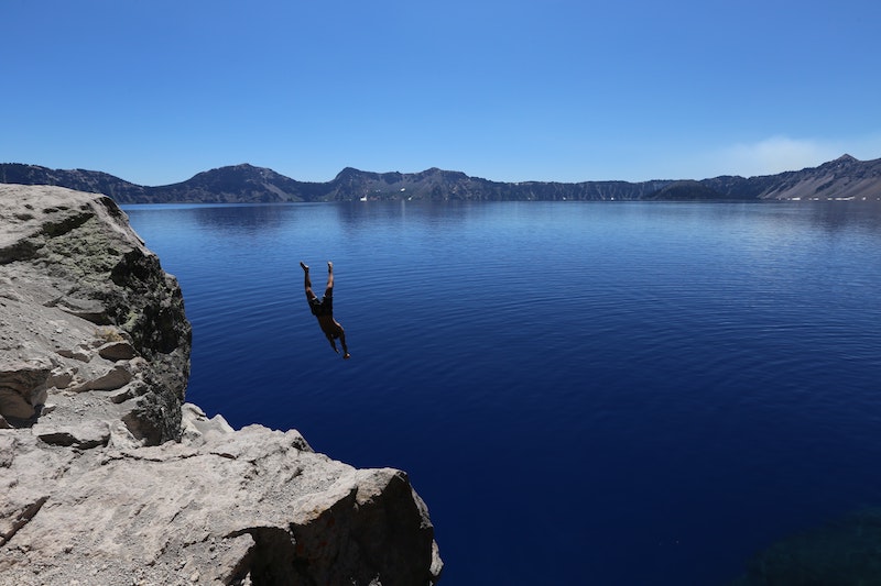 Man jumping in freezing lake representing the fear of financial shortage rising when deciding to take a year off